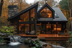 a house in the woods with a waterfall running through it's front yard and deck area