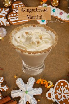 gingerbread martini with whipped cream in a glass bowl surrounded by cookies and other holiday decorations