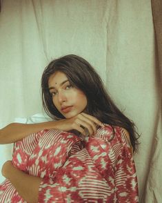 a woman laying on top of a bed covered in a red and white comforter