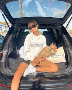 a woman sitting in the trunk of a car