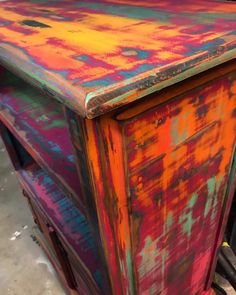 an old dresser is painted bright and colorful