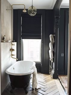 a bathroom remodel with black walls and wood flooring is featured in this article