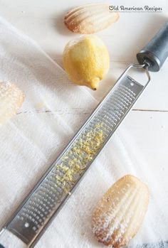 three lemons and a grater on a white towel