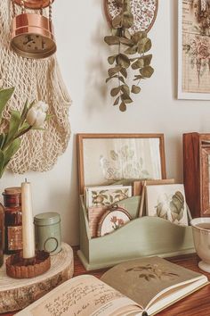 an open book sitting on top of a wooden table next to a vase filled with flowers