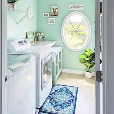 a washer and dryer in a room with a circular window on the wall