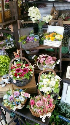 several baskets filled with flowers sitting on top of a table in front of other items