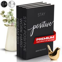 the book is next to a vase with a plant in it and an ad for stay positive