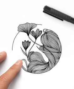 a drawing of flowers in a circle on top of a sheet of paper next to a marker pen