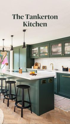 a large kitchen with green cabinets and stools in front of an island countertop