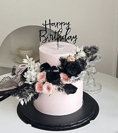 a white and black birthday cake with flowers on it