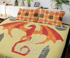 a bed with an orange and black dragon quilted on it's coverlet