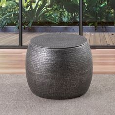 a large round ottoman sitting on top of a carpeted floor next to a window