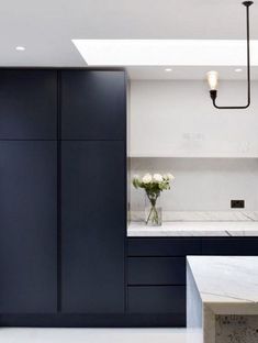 a kitchen with black cabinets and white countertops is seen in this image from the front view