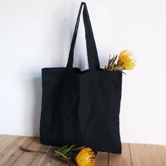 Experience both style and functionality with our Black Canvas Tote Bag. Crafted from durable canvas material, this tote combines a sleek black design with practical dimensions. Whether you're heading to the market or out for a casual day, this versatile tote is perfect for carrying your essentials. Elevate your daily style with the simplicity and sophistication of our Black Canvas Tote Bag. Available in two sizes Canvas Tote Bag Outfit, Black Canvas Tote Bag, Colored Burlap, Lame Fabric, Lace Bag, Monks Cloth, Jute Tote Bags, Burlap Bags, Ticking Fabric