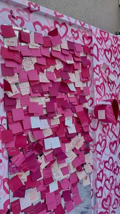 a wall covered in pink and white paper with hearts cut out of it's sides