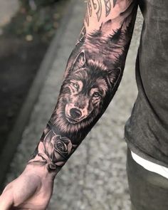 a man's arm with a wolf and rose tattoo on the left forearm,