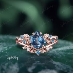 a ring with an oval blue stone surrounded by leaves