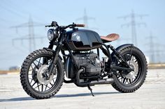 a black motorcycle parked on top of a parking lot with power lines in the background