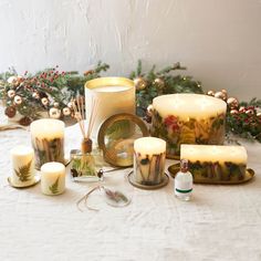 there are many candles on the table next to each other and some decorations around them