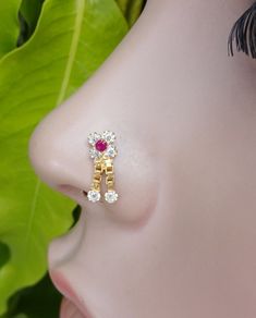 a close up of a person's nose with a pair of earrings on it