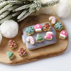 decorated cookies are on a tray next to a christmas tree and snowflakes