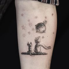 a small tattoo on the leg of a person with a cat and dog sitting under stars