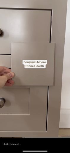 someone is holding the door handle on a cabinet with stickers that say, belgium more stone hearth