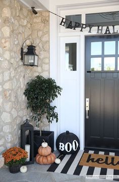 a front porch decorated for halloween with pumpkins and decorations