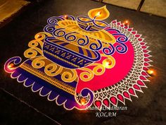 a decorated floor with lit candles and an intricate design on it for diwaling