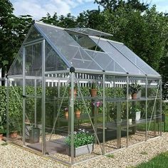 a small greenhouse with several plants growing in the ground and on top of it's roof