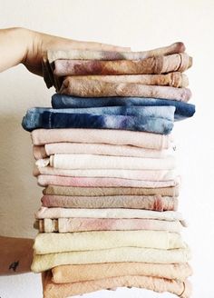 a person holding up a stack of folded towels