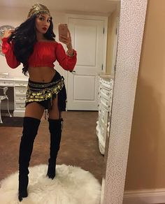 a woman taking a selfie in a mirror wearing a belly ring and high heel boots