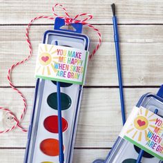 two paintbrushes with cards in them sitting next to each other on a table