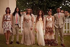 a group of people standing next to each other in front of a white picket fence