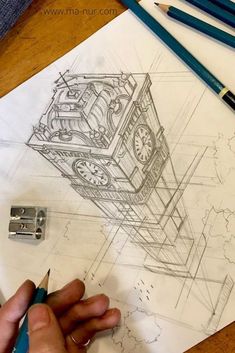 a drawing of a clock on top of a piece of paper with pencils next to it