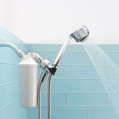 a faucet that is connected to a shower head in a blue tiled bathroom