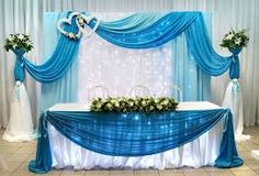 a blue and white wedding set up with flowers