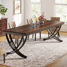 a dining room table with chairs around it and a rug on the floor next to it