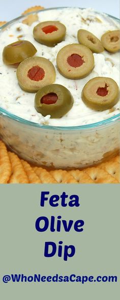 a close up of a bowl of food with crackers and olives on the side