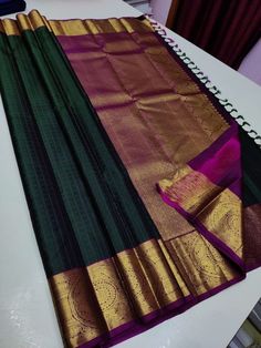 a green and purple saree sitting on top of a white table next to a notebook