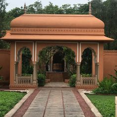 an orange gazebo sitting in the middle of a lush green park