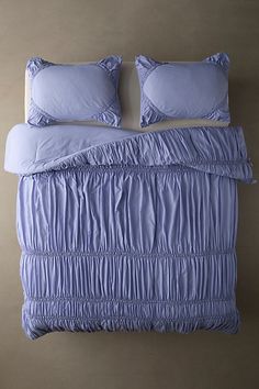 a bed with two pillows on top of it and a pillow case in the middle