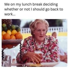 an older woman sitting at a table with fruit on it