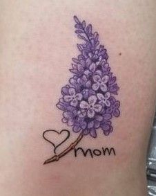 a tattoo with the word mom written on it and a bouquet of flowers in the shape of a heart