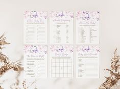 wedding seating chart with pink flowers and butterflies on white background next to fern leaves in foreground