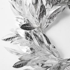 a close up of a metal leaf decoration on a white wall with black and white background