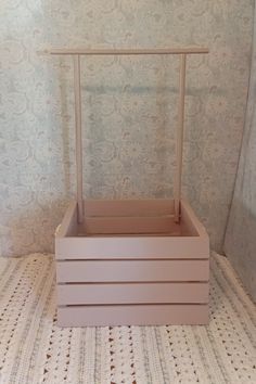 a pink wooden box sitting on top of a white tiled floor next to a wall