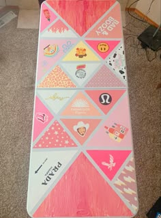 a pink and white snowboard sitting on top of a carpeted floor