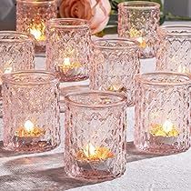 there are many glass cups with candles in them