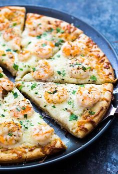 a pizza with shrimp and cheese cut into slices